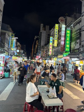 People sitting at tables in a street