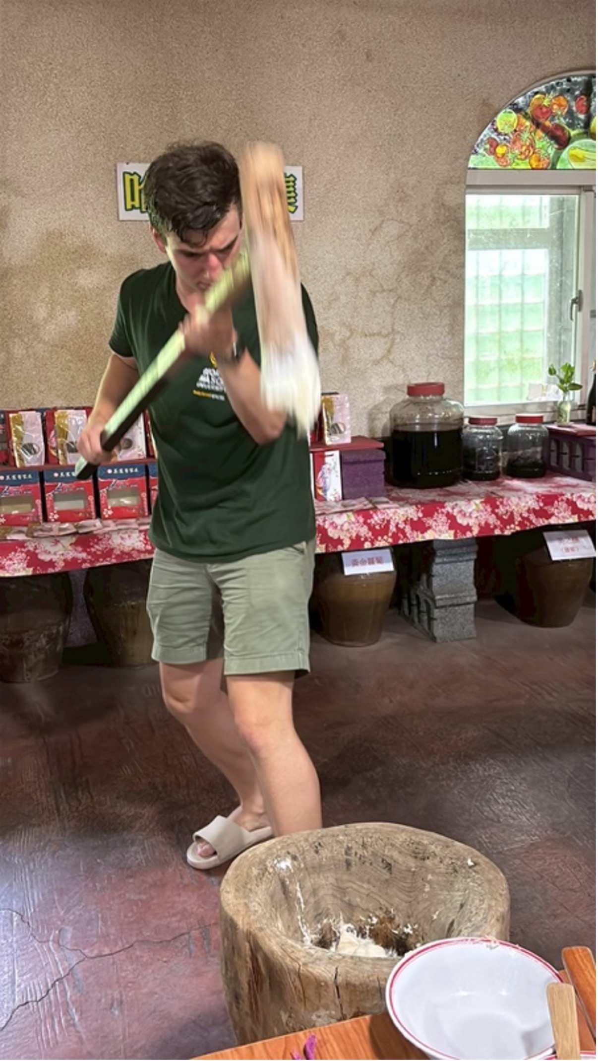 I am using a giant mallet to make mochi by beating sticky rice into a big pot.