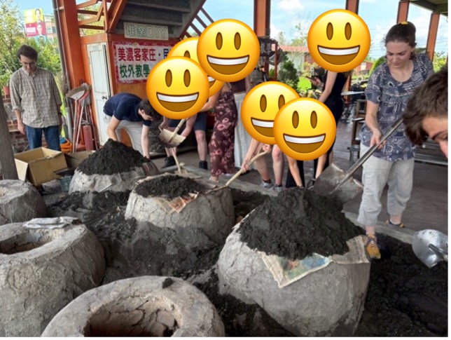 Inserting pot and food into the stone oven and covering with paper and sand.