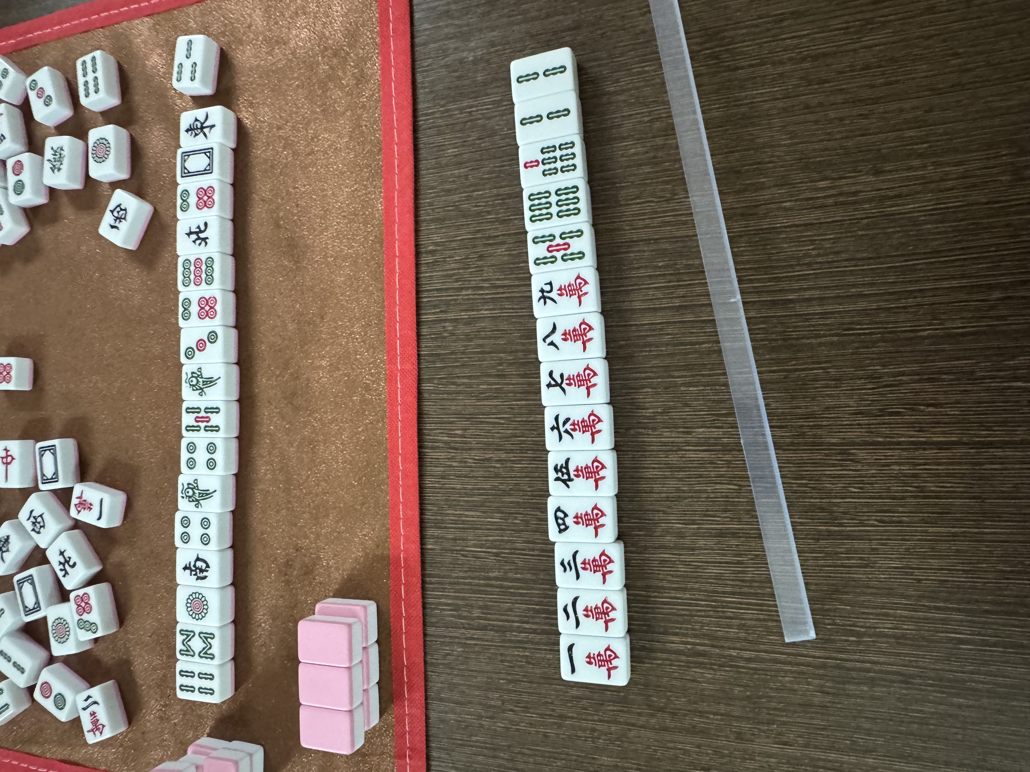 Close-up of a mahjong hand showing the characters suit from one to nine (萬).