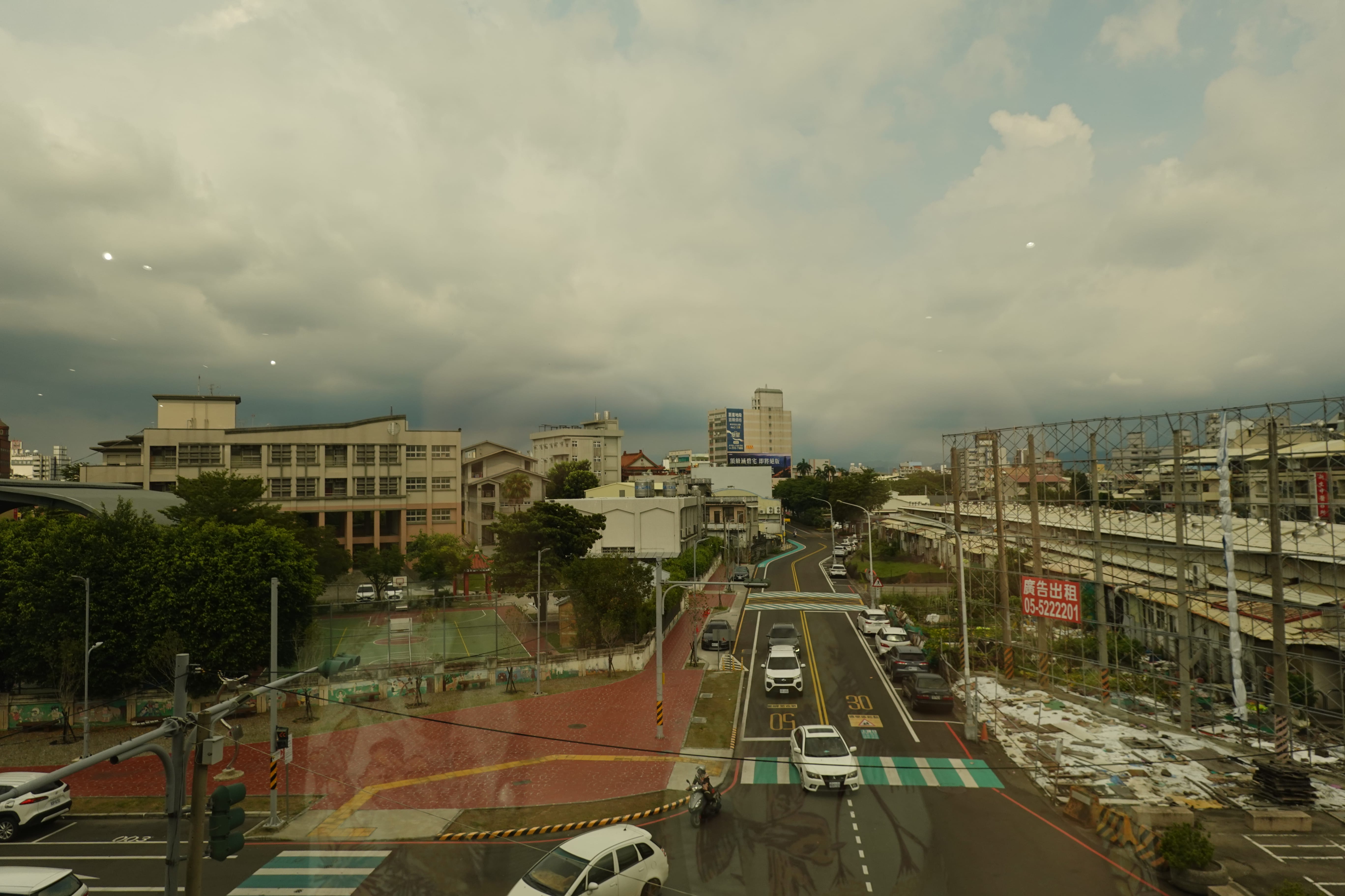 Overcast city street seen through a large window with indoor reflections from a café.